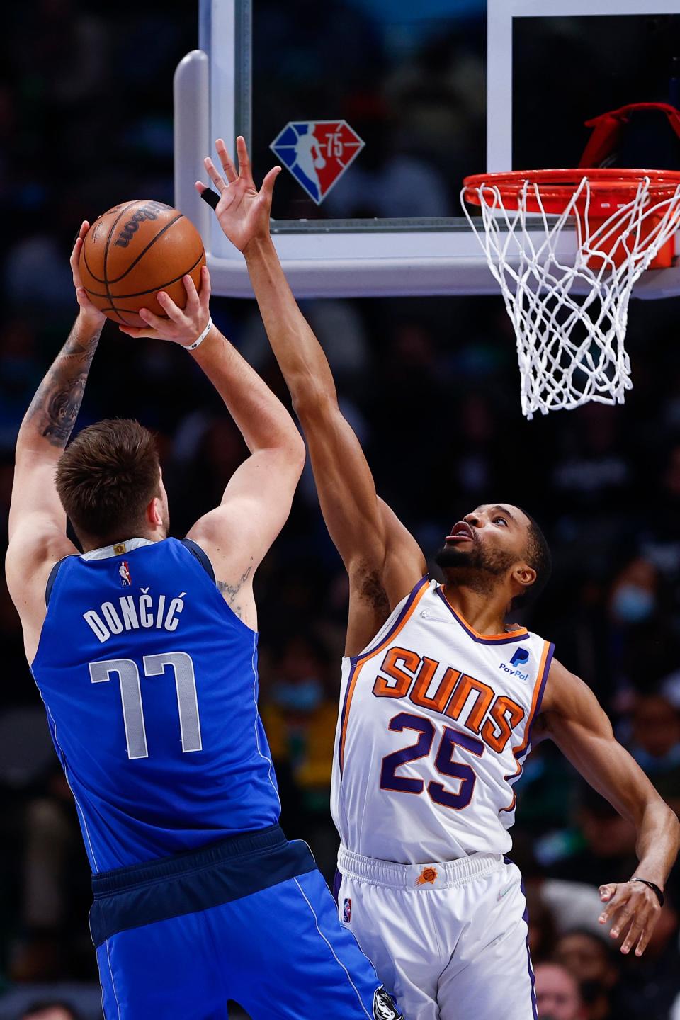 Dallas Mavericks guard Luka Doncic (77) shoots as Phoenix Suns forward Mikal Bridges (25) defends during the first half of an NBA basketball game Thursday, Jan. 20, 2022, in Dallas. (AP Photo/Brandon Wade)