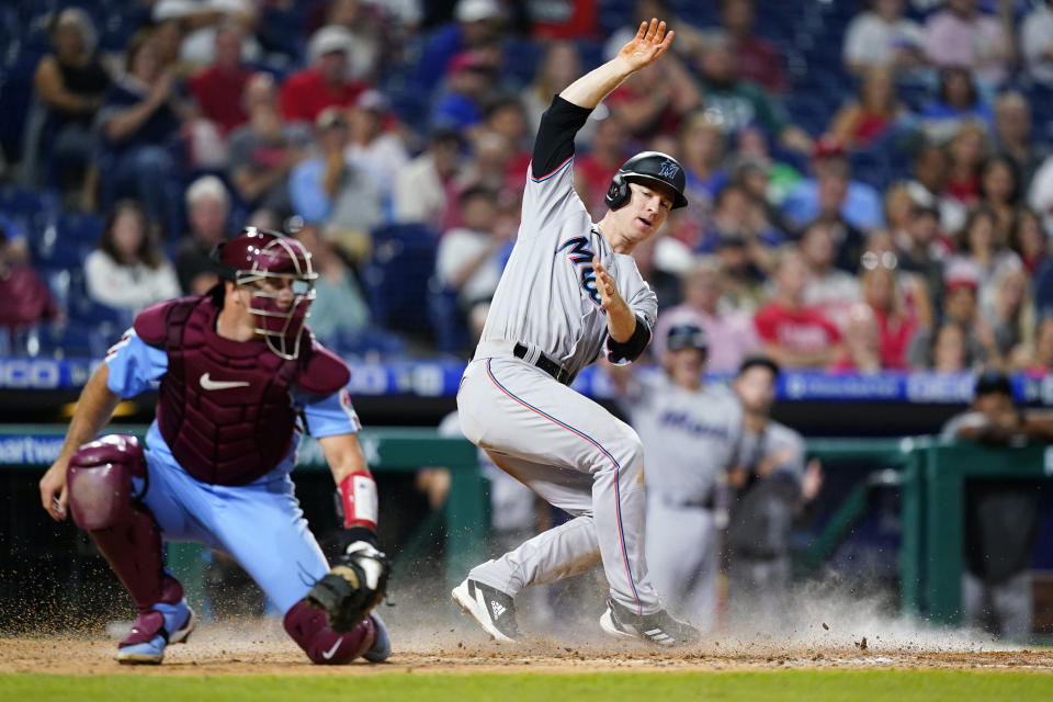 Miami Marlins' Joey Wendle, right, scores past Philadelphia Phillies catcher J.T. Realmuto on a single by Brian Anderson during the ninth inning of a baseball game, Thursday, Sept. 8, 2022, in Philadelphia. (AP Photo/Matt Slocum)