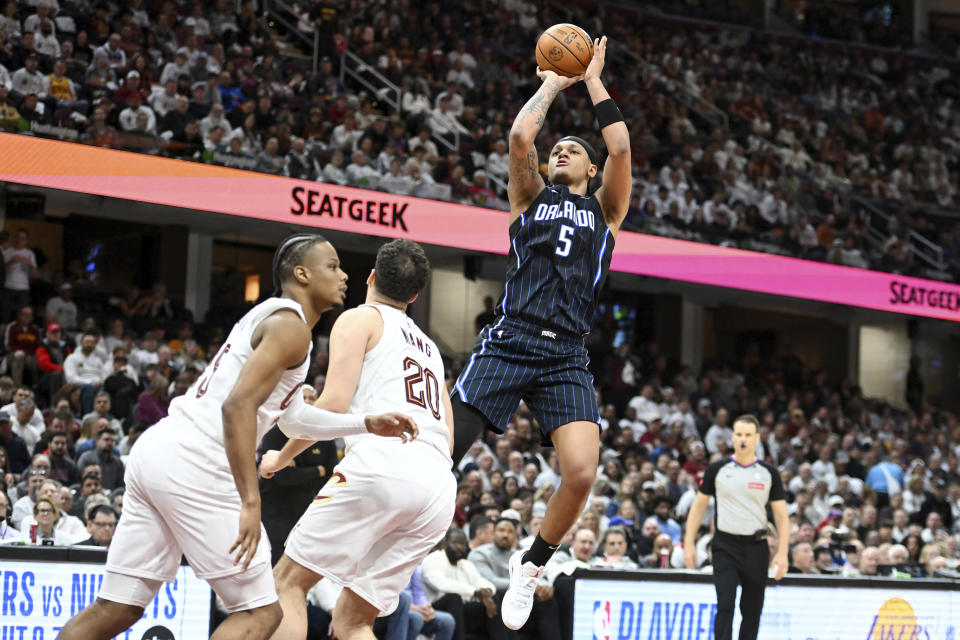 Orlando Magic's Paolo Banchero (5) shoots a 3-point basket over Cleveland Cavaliers' Georges Niang (20) during the second half in Game 1 of an NBA basketball first-round playoff series, Saturday, April 20, 2024, in Cleveland. (AP Photo/Nick Cammett)