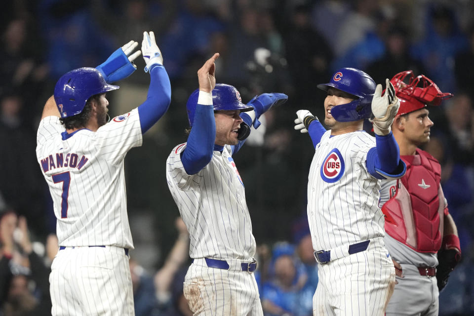 Chicago Cubs' Seiya Suzuki, right front, celebrates with Dansby Swanson (7) and Nico Hoerner after Suzuki's grand slam off Cincinnati Reds starting pitcher Hunter Greene during the second inning of a baseball game Saturday, June 1, 2024, in Chicago. (AP Photo/Charles Rex Arbogast)