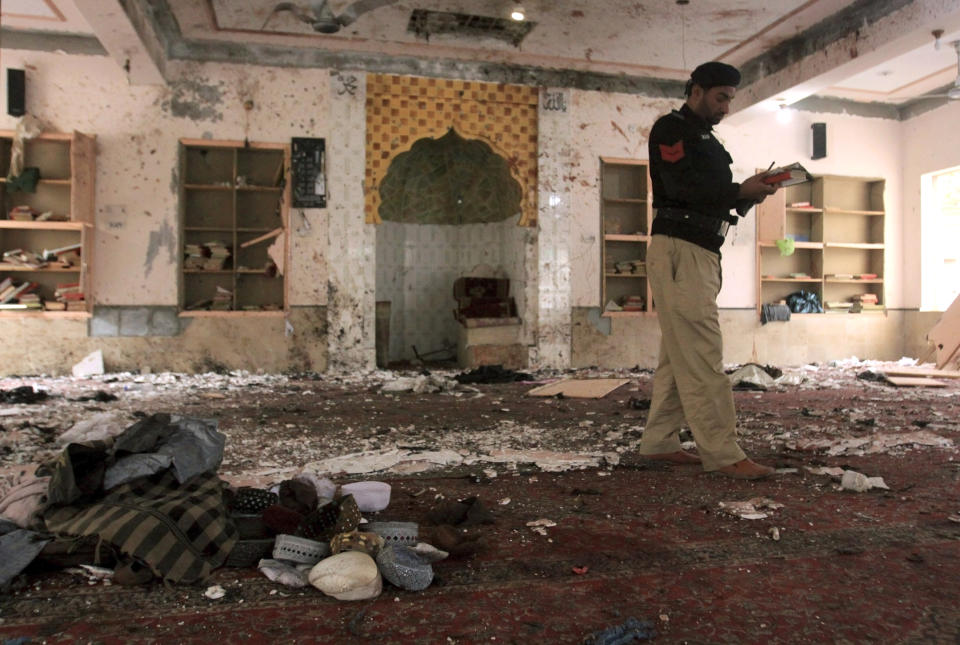 A police officer examines the site of Friday's bomb explosion inside a mosque in Quetta, Pakistan, Saturday, Jan. 11, 2020. A powerful explosion ripped through a mosque in Quetta, the provincial capital of Baluchistan province, during the evening prayers on Friday, killing a senior police officer and other some people and wounded many worshipers. (AP Photo/Arshad Butt)