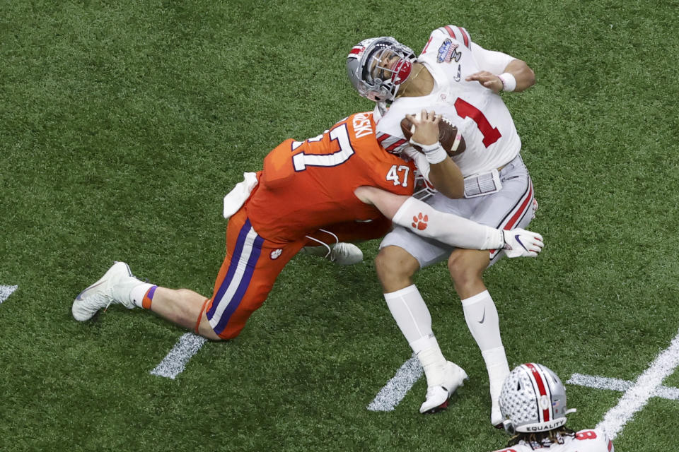 Ohio State quarterback Justin Fields gets hit by Clemson linebacker James Skalski during the first half of the Sugar Bowl NCAA college football game Friday, Jan. 1, 2021, in New Orleans. Skalski was ejected from the game for targeting. (AP Photo/Butch Dill)