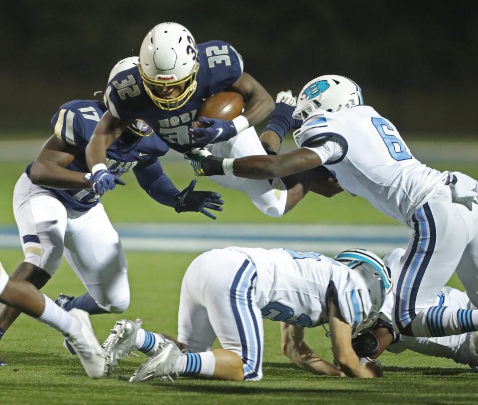 Hoban running back Lamar Sperling dives over two Benedictine defenders for a first-quarter first down, Friday, Oct. 15, 2021 at Dowed Field.