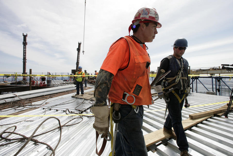 Ironworkers Adam Cross, left, and Steven Cross walk across the top deck of the World Trade center after connecting two steel columns, left, to make the tower New York City's tallest skyscraper, Monday, April 30, 2012 in New York. The cousins are from the Kahnawae native american reservation in Quebec, Canada. One World Trade Center is being built to replace the twin towers destroyed in the Sept. 11 attacks. It reached just over 1,250 feet on Monday. That's just taller than the observation deck on the Empire State Building. (AP Photo/Mark Lennihan, Pool)