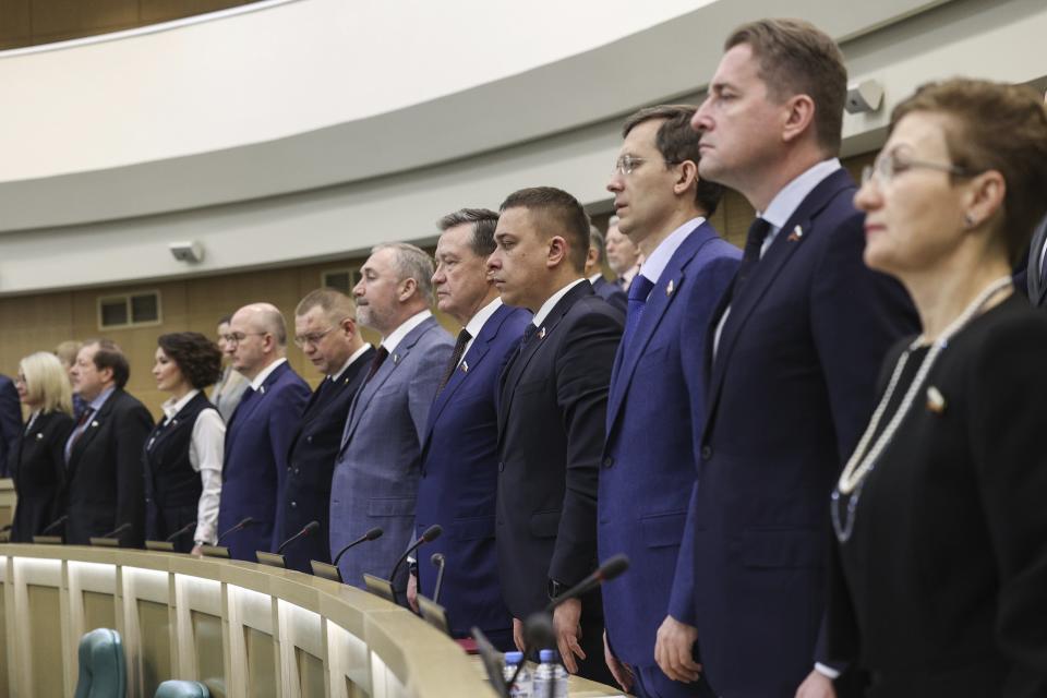 In this photo provided by The Federation Council of The Federal Assembly of The Russian Federation Press Service, lawmakers of Federation Council of the Federal Assembly of the Russian Federation listen to the national anthem prior to a session in Moscow, Russia, on Wednesday, Feb. 7, 2024. The upper house of Russia's parliament has endorsed a bill that would allow authorities to confiscate money, valuables and other assets from people convicted of spreading "deliberately false information" about the country's military. (Federation Council of the Federal Assembly of the Russian Federation via AP)