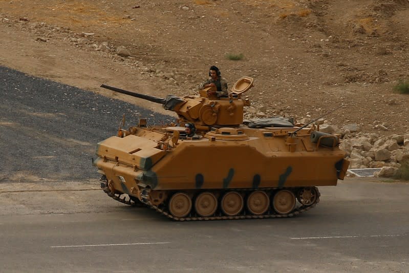 Turkish soldiers on an infantry fighting vehicle (IFV) drive near the Turkish-Syrian border in Ceylanpinar