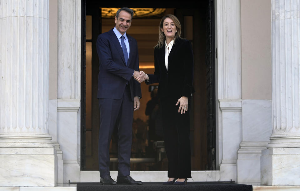 Greece's Prime Minister Kyriakos Mitsotakis, left, shakes hands with European Parliament President Roberta Metsola before their meeting at Maximos Mansion in Athens, Greece, Tuesday, Feb. 20, 2024. Metsola is in Athens on Tuesday, as part of her campaign to raise awareness and encourage people to vote in the European Parliament elections in June. (AP Photo/Thanassis Stavrakis)