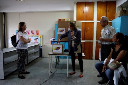 A woman casts her vote in a polling station during a nationwide election for new governors in Caracas, Venezuela, October 15, 2017. REUTERS/Carlos Garcia Rawlins