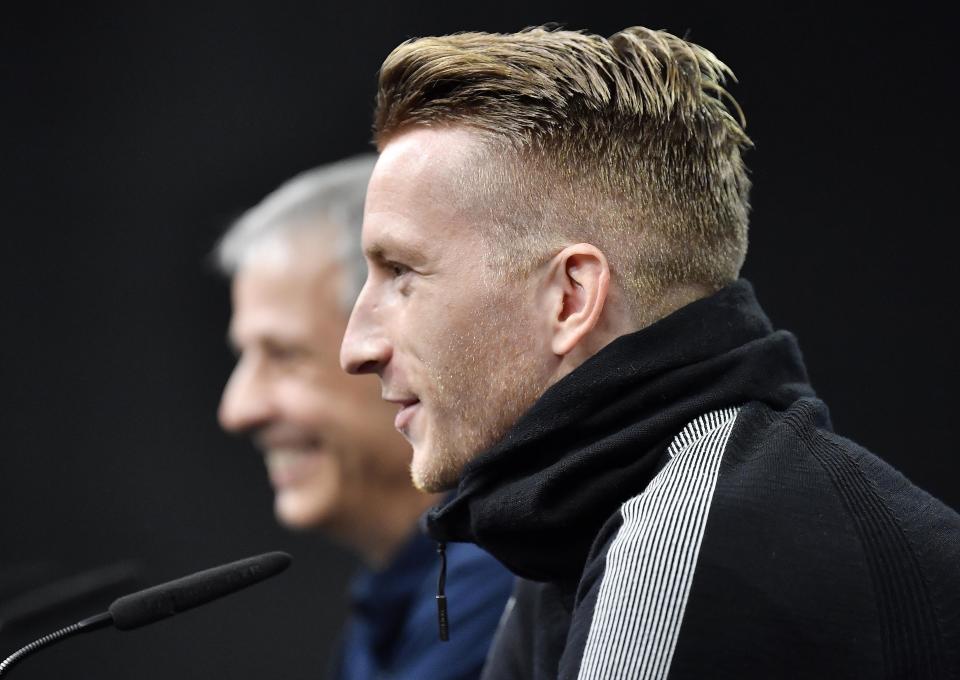 Dortmund's Marco Reus, right, and Dortmund coach Lucien Favre talk to the media at a press conference prior the Champions League group A soccer match between Borussia Dortmund and Atletico Madrid in Dortmund, Germany, Tuesday, Oct. 23, 2018. (AP Photo/Martin Meissner)