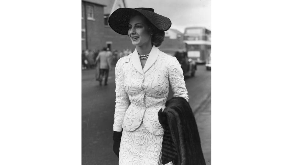 16th June 1953: On the first day of the Royal Ascot meeting, model Fiona Campbell Walter (later Baroness von Thyssen) wears a black straw hat, a white corded suit and pearl necklace and is carrying a fur stole. (Photo by Keystone/Getty Images)