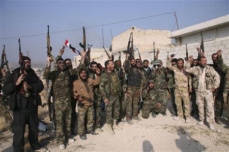 Forces loyal to Syria's President Bashar al-Assad hold up their weapons as they cheer in the town of Safira November 1, 2013. REUTERS/George Ourfalian