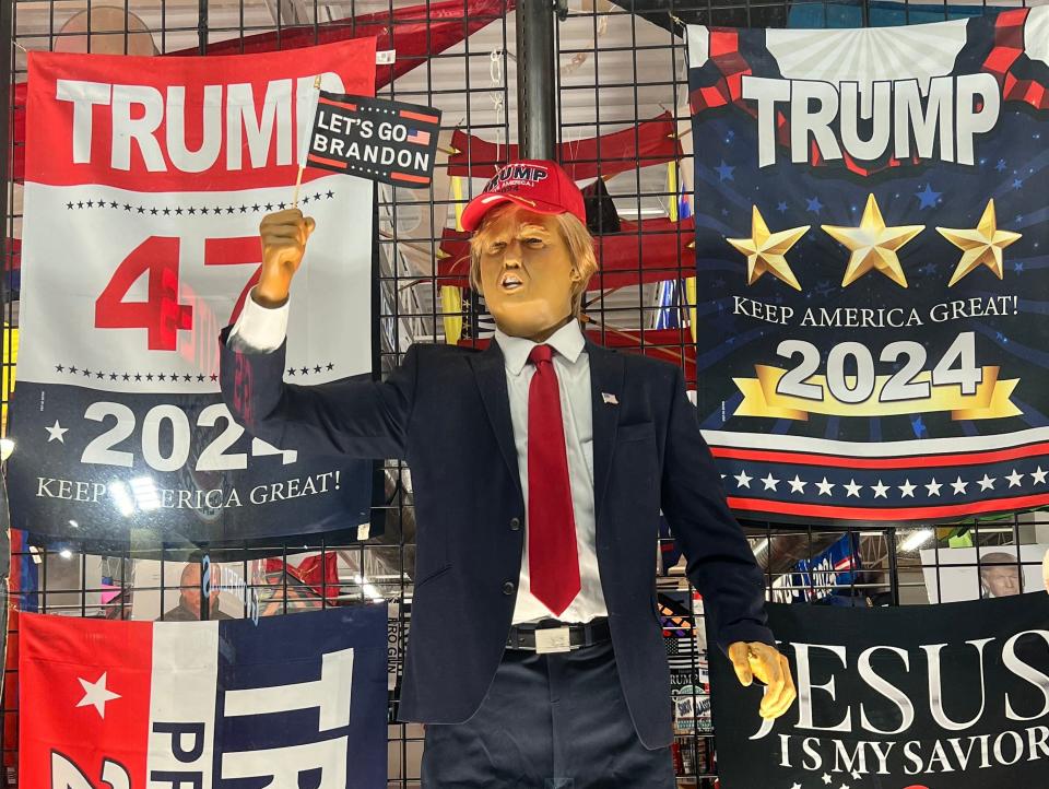 Trump figure holding a "Let's go Brandon" flag.