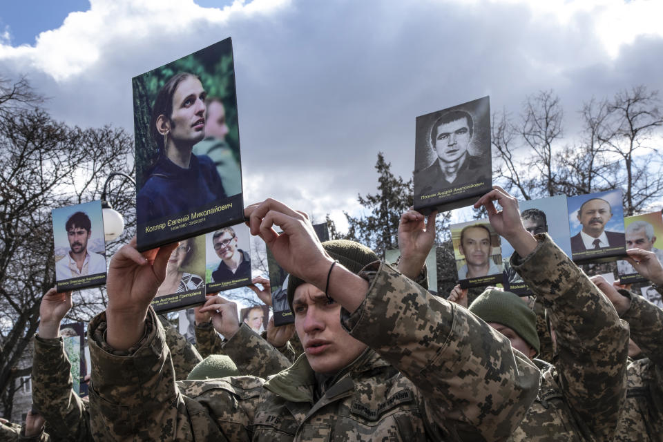 KHRAKIV,UKRAINE - FEBRUARY 20:  (FRANCE OUT, IMAGES EMBARGOED FROM USAGE IN FRANCE FOR 30 DAYS FROM CAPTURE DATE) Members of the public hold photos at a tribute for the 107 protesters killed eight years ago during the Maidan revolution in Nebesna Sotnya Square on February 20,2022 in Kharkiv, Ukraine. In February 2014, the months-long Euromaidan protests culminated in violent clashes between protesters and riot police, leading to the deaths of over 100 people and the ousting of president Viktor Yanukovych, who had sparked the protests by rejecting a pact with the European Union in favor of closer ties with Russia. Eight years later, the country again finds itself at center stage in the geopolitical tussle between Russia and the West.(Photo by Laurent Van der Stockt for Le Monde/Getty Images)