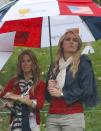 Tiger Woods girlfriend Lindsey Vonn (R) stands under an umbrella with Fred Couples girlfriend Nadine Moze during the Singles matches for the 2013 Presidents Cup golf tournament at Muirfield Village Golf Club in Dublin, Ohio October 6, 2013. REUTERS/Jeff Haynes (UNITED STATES - Tags: SPORT GOLF ENTERTAINMENT)