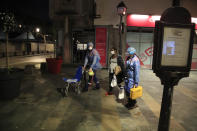 In this photo taken Thursday, March 26, 2020, members of the Civil Protection service, Vincent Jactel, left, and Aurore Lejeune, right, escort a 27-year-old pregnant woman suspected of being infected with the Covid-19 virus in Paris. (AP Photo/Michel Euler)