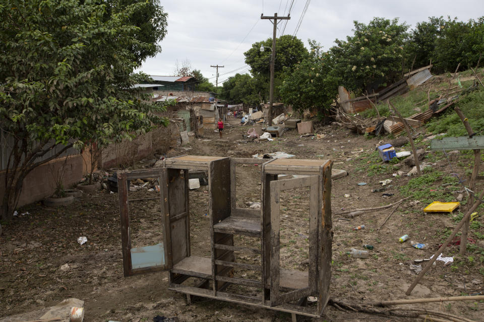 A muddied wardrobe stands amid the rubble of homes destroyed by last year's hurricanes Eta and Iota in La Lima, on the outskirts of San Pedro Sula, Honduras, Monday, Jan. 11, 2021. The suburb of San Pedro Sula has seen small businesses begin to reopen, but in outlying neighborhoods, the streets are still full of debris, dead animals, snakes and burning mattresses. (AP Photo/Moises Castillo)