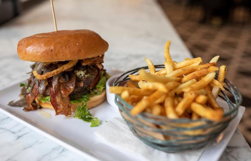 A burger and a side of fries at the Goblet Bar counter is a sample of the food served at the Sugar Factory American Brasserie in Detroit on Tuesday, Sept. 6, 2022.