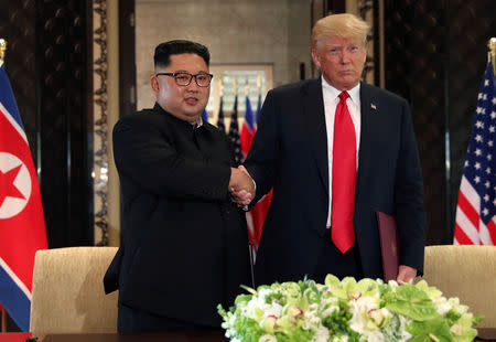 FILE PHOTO: U.S. President Donald Trump shakes hands with North Korea's leader Kim Jong Un after they signed documents that acknowledged the progress of the talks and pledge to keep momentum going, after their summit at the Capella Hotel on Sentosa island in Singapore June 12, 2018. REUTERS/Jonathan Ernst/File Photo