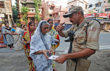 A security personnel checks the identity card of a woman as she stands in a queue with others to cast their vote at a polling station during the fifth phase of general election in Howrah, on the outskirts of Kolkata, India May 6, 2019. REUTERS/Rupak De Chowdhuri