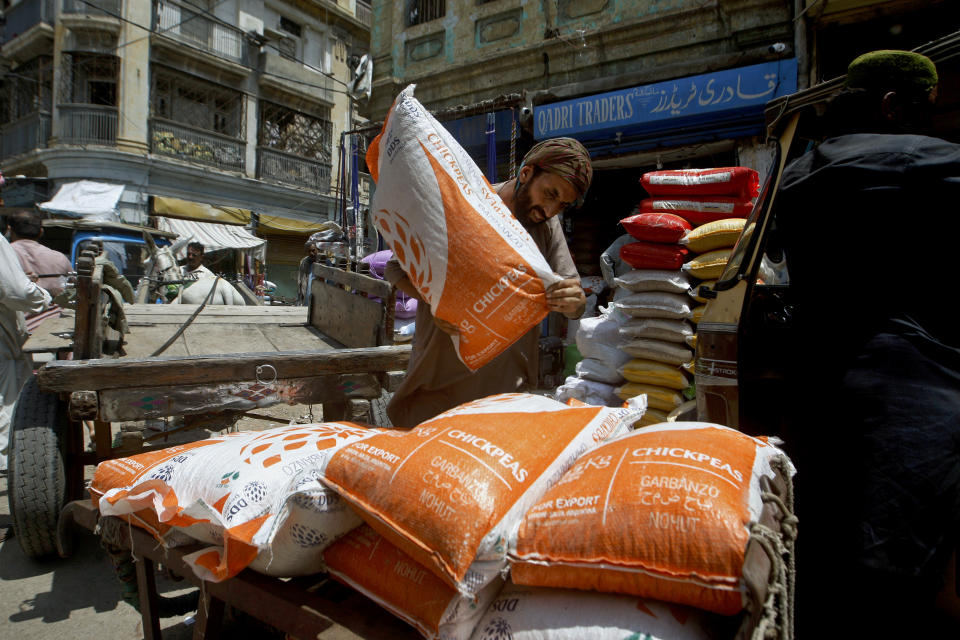 A laborer unload sacks of chickpeas at a market in Karachi, Pakistan, Thursday, July 14, 2022. The International Monetary Fund said Thursday it had reached a preliminary agreement with Pakistan to revive a $6 billion bailout package for this impoverished Islamic nation, which has been facing a serious economic crisis since last year. (AP Photo/Fareed Khan)