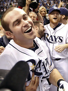 Evan Longoria was swarmed by teammates and media following his 12th-inning walkoff home run that clinched the AL wild card for the Rays