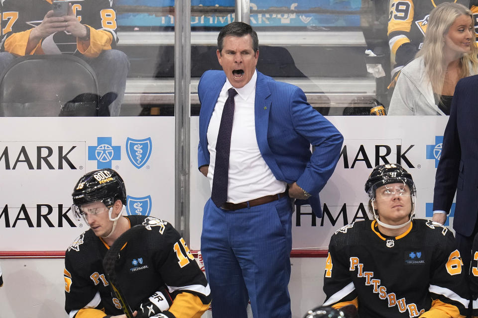 Pittsburgh Penguins head coach Mike Sullivan, center, disagrees with a referee's call during the third period of an NHL hockey game against the Minnesota Wild in Pittsburgh, Thursday, April 6, 2023. (AP Photo/Gene J. Puskar)