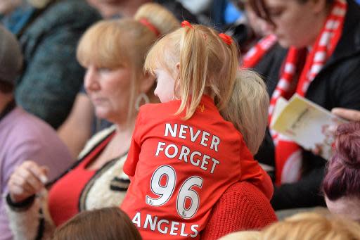 Una niña pequeña lleva una camiseta en memoria de las 96 víctimas de Hillsborough durante el acto del 25 aniversario de la tragedia, en Anfield, Liverpool, el 15 de abril de 2014 (AFP | Paul Ellis)