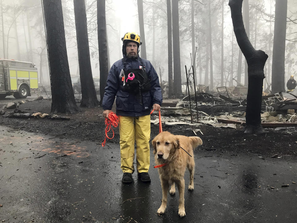 Eric Darling and his dog are part of a search team from Orange County, California. Theirs is one of several teams conducting a second search of a mobile home park after the deadly Camp fire in Paradise. (Photo: ASSOCIATED PRESS)