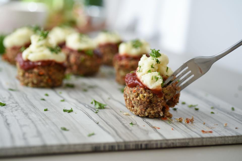 Meatloaf cupcakes are topped with mashed potatoes.