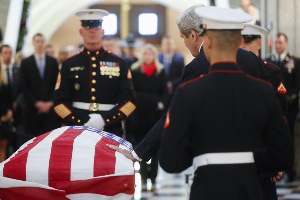 U.S. Secretary of State John Kerry touches John Glenn's casket as he lies in honor, Friday, Dec. 16, 2016, in Columbus, Ohio. Glenn's home state and the nation began saying goodbye to the famed astronaut who died last week at the age of 95. (AP Photo/John Minchillo)