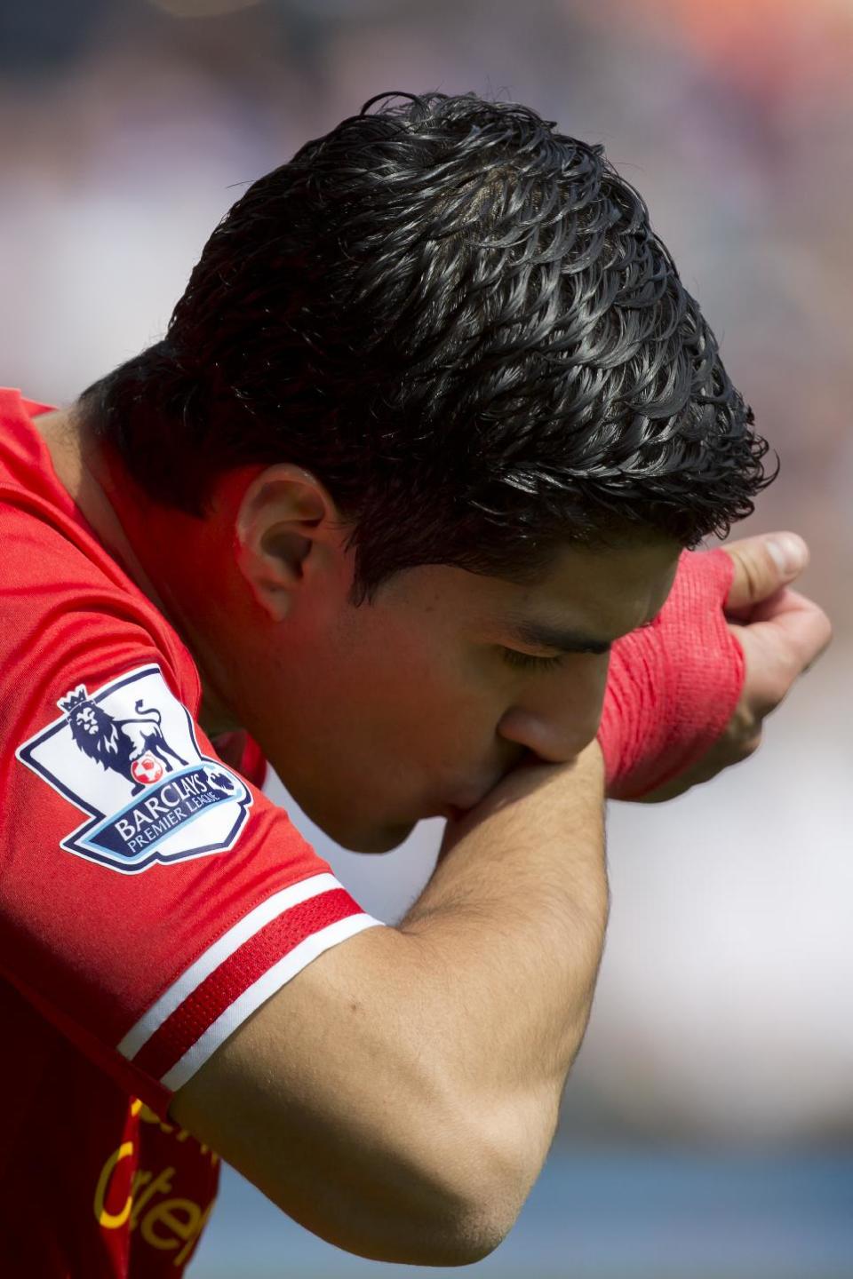 Liverpool's Luis Suarez kisses his wrist as he takes to the pitch for his team's English Premier League soccer match against Chelsea at Anfield Stadium, Liverpool, England, Sunday April 27, 2014. (AP Photo/Jon Super)
