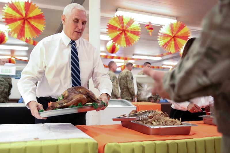 U.S. Vice President Mike Pence helps to serve a Thanksgiving meal to U.S. troops in a dining facility at Camp Flores on Al Asad Air Base