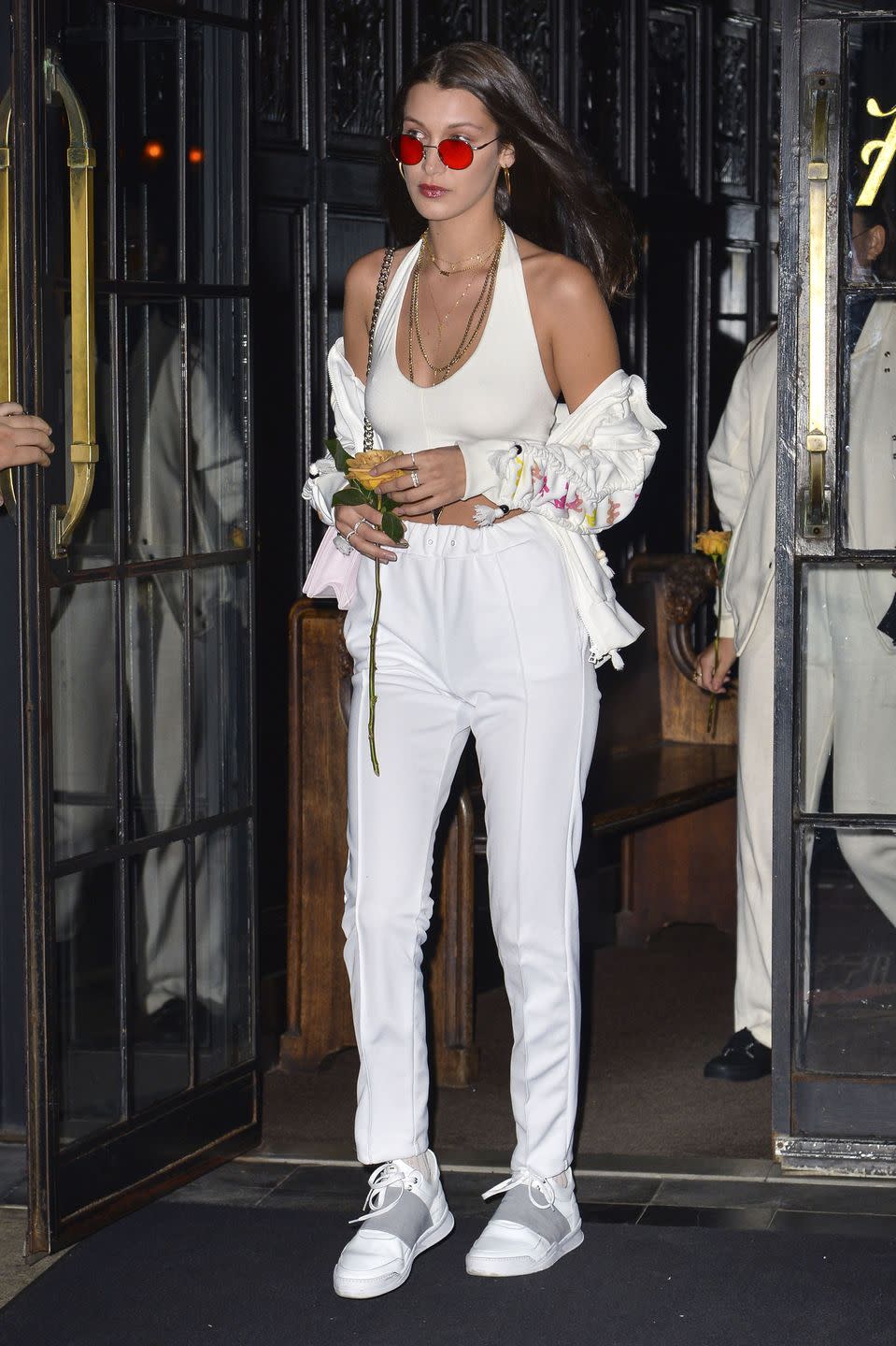 <p>The model stepped out in NYC wearing a white crop top and sweatpants with a sporty hoodie and sneakers, plus layer upon layer of gold chain necklaces and rose-tinted shades. </p>