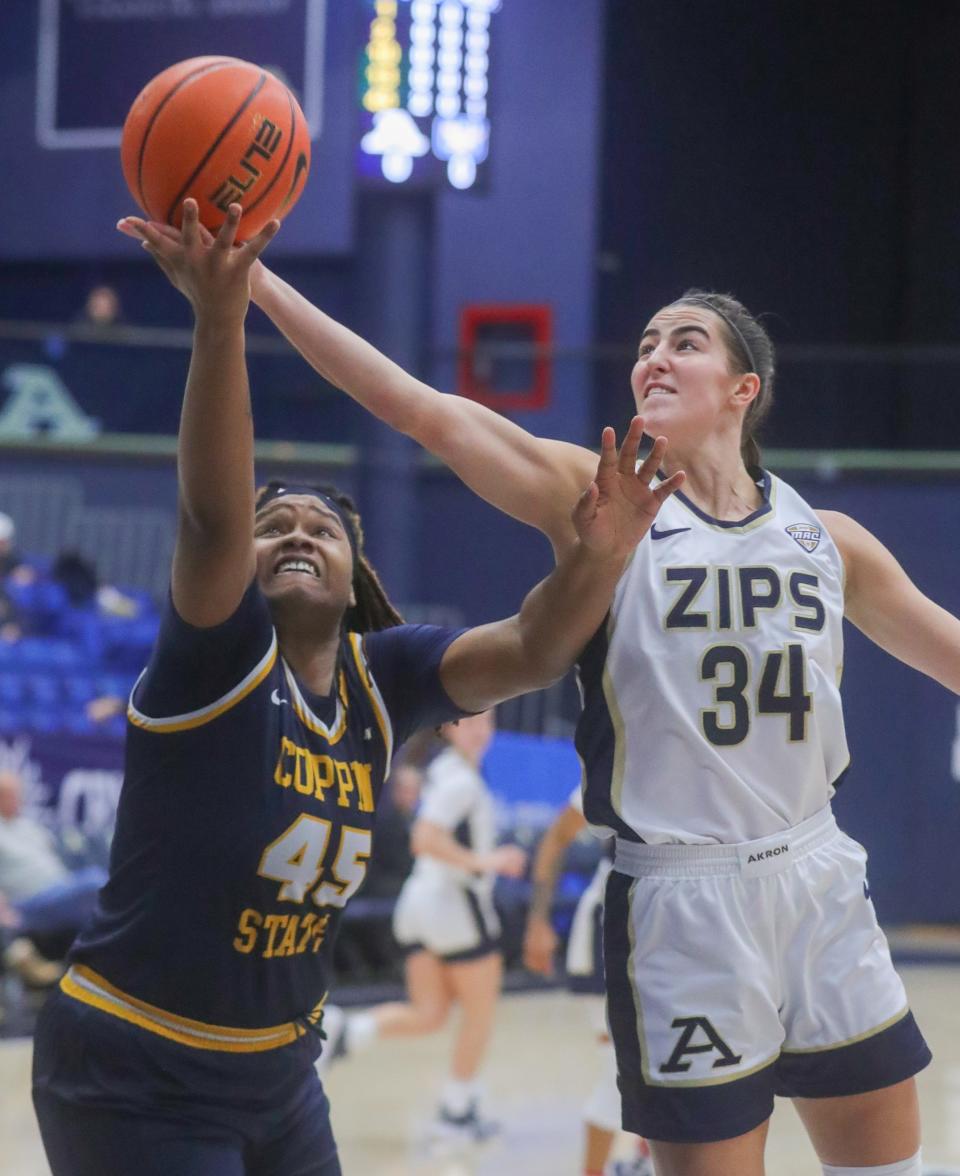 University of Akron's Reagan Bass grabs a rebound over Coppin State's Jalynda Salley on Thursday, Dec. 29, 2022 at Rhodes Arena.