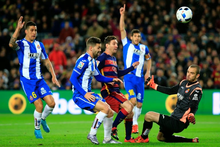 Barcelona's Lionel Messi (C) tries to scores past Espanyol goalkeeper Pau Lopez during their Copa del Rey match at Camp Nou stadium on January 6, 2016