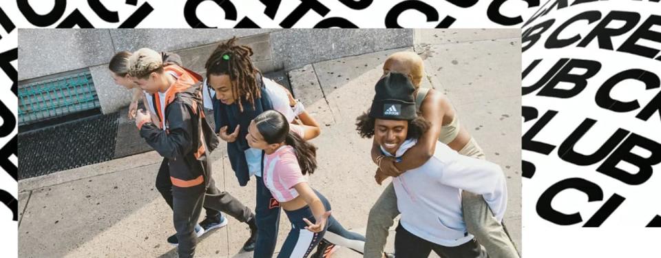 group of people walking talking and smiling and adidas creators club text behind them