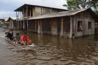 Residents navigate flooded streets in Anama, Amazonas state, Brazil, Thursday, May 13, 2021. (AP Photo/Edmar Barros)