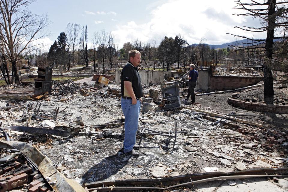 Members of FEMA and the Small Business administration look at a burned home in Colorado Springs, Colo., on Monday, July 9, 2012. Members of FEMA, the SBA and Colorado's Disaster Office assessed damages in the area burned by the Waldo Canyon wildfire.  (AP Photo/Ed Andrieski)