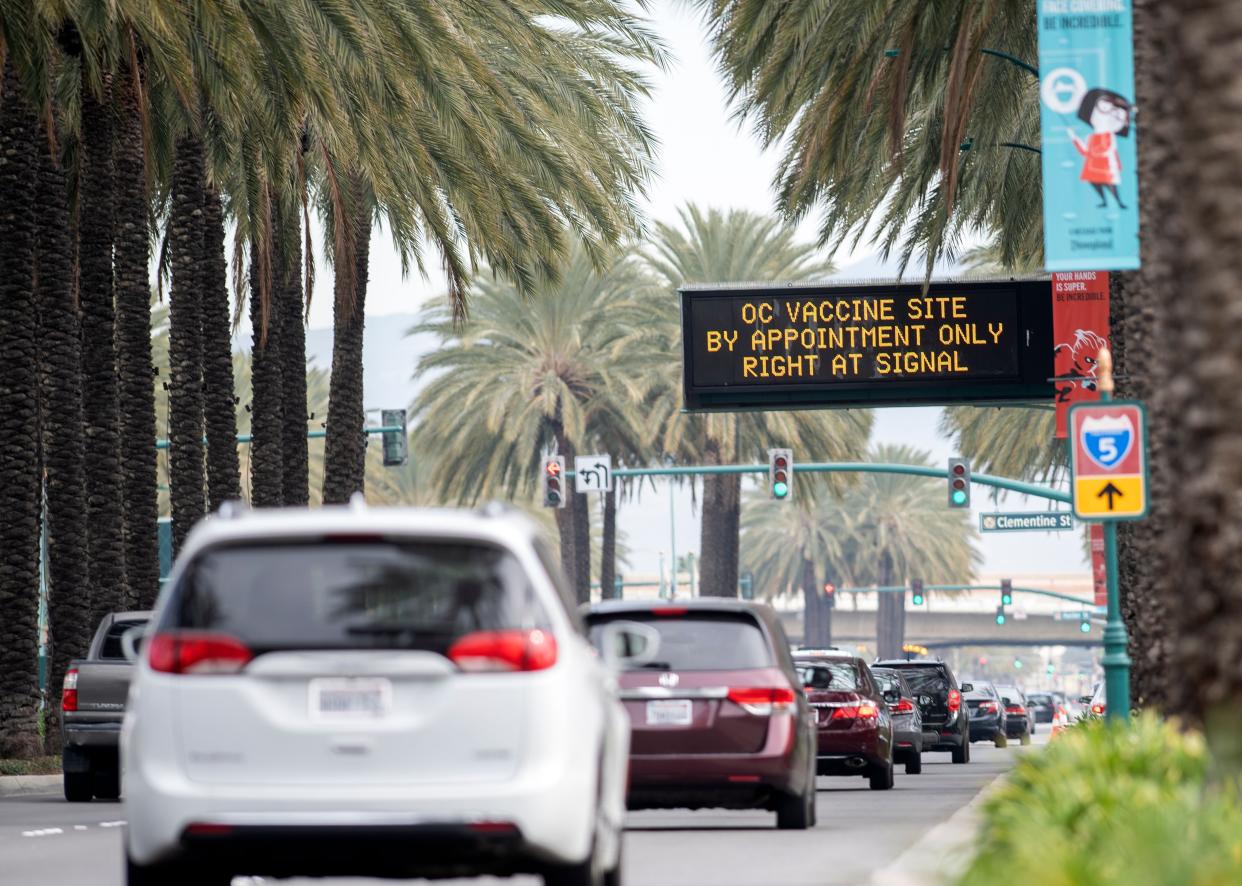 People arrive at a Disneyland parking lot to receive COVID-19 vaccines on the opening day of the Disneyland Covid-19 vaccination "super Point-of-Dispensing" (POD) site, Jan. 13, 2021, in Anaheim, Calif.