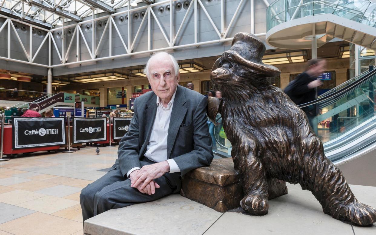 Michael Bond pictured with the Paddington Bear statue on Paddington Station in London - Andrew Crowley 