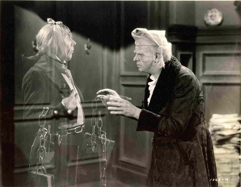 In the 1938 version of “A Christmas Carol,” Reginald Owen, right, plays curmudgeonly Ebenezer Scrooge, confronted by the ghost of his former partner, Marley (played by Leo G. Carroll).