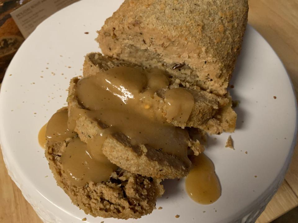 Trader joe's vegan roast on a white plate and topped with gravy