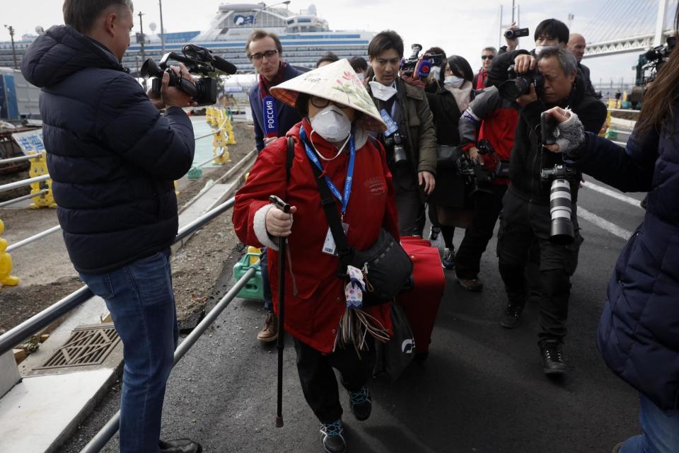 A passenger is surrounded by the media after she disembarked from the quarantined Diamond Princess cruise ship on Wednesday: AP