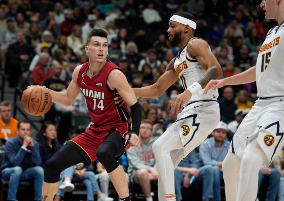 El escolta del Heat Tyler Herro (izq.) trata de pasar la marca de Bruce Brown (centro) y Nikola Jokic, de los Nuggets, en el partido celebrado el 30 de diciembre de 2022 en Denver.