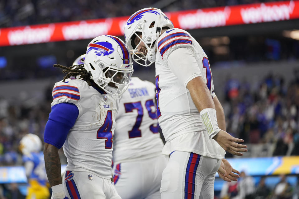 Buffalo Bills quarterback Josh Allen, right, celebrates his rushing touchdown with running back James Cook (4) during the first half of an NFL football game against the Los Angeles Chargers, Saturday, Dec. 23, 2023, in Inglewood, Calif. (AP Photo/Ashley Landis)