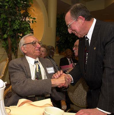 Assemblyman Samuel Colman being congratulated after receiving a public service award.