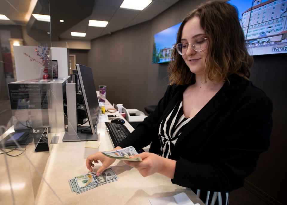 Erin Jones, a teller for Ent Credit Union, counts out cash for a withdrawal for a customer at Ent Credit Union in Timnath in 2021. Bellco Credit Union will expand into the Fort Collins market later this year with a new branch on East Harmony Road.