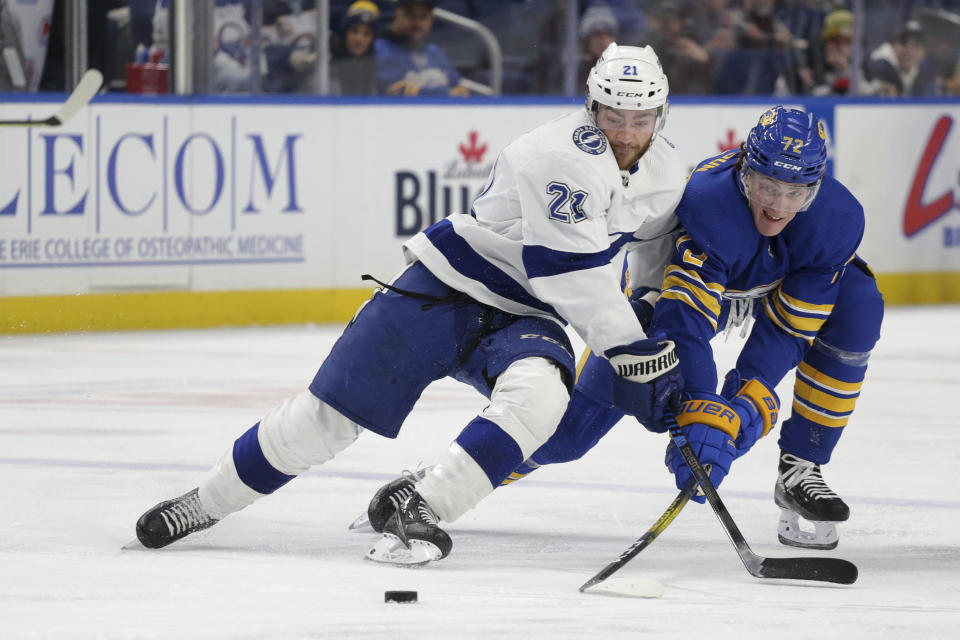 Tampa Bay Lightning center Brayden Point (21) and Buffalo Sabres right wing Tage Thompson (72) battle for possession of the puck during the second period of an NHL hockey game Monday, Nov. 28, 2022, in Buffalo, N.Y. (AP Photo/Joshua Bessex)