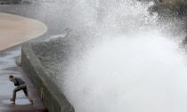 Un hombre escapa de las poderosas olas que rompen contra la playa durante la marea alta en Biarritz.