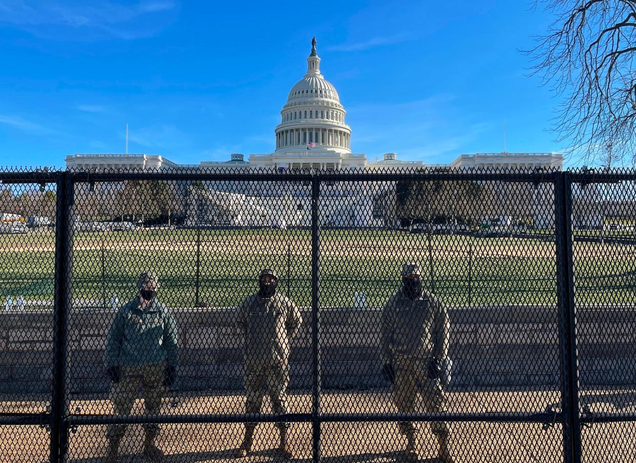 <p>National Guard soldiers guard the grounds of the US Capitol from behind a security fence in Washington, DC</p> (AFP via Getty Images)
